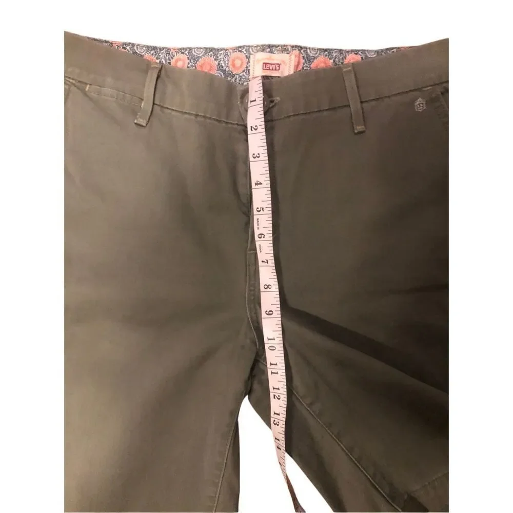 Levi’s olive green flat-front chino shorts. Button and zip fly closure, belt loo